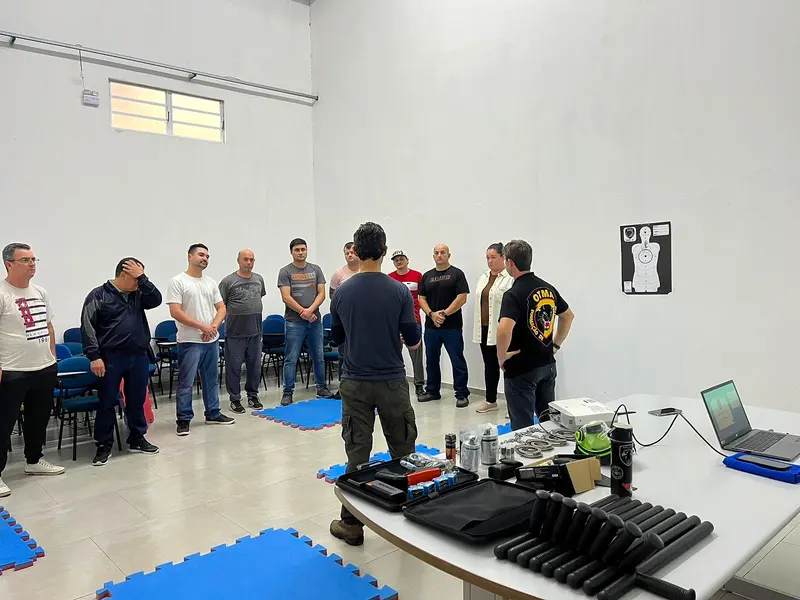 Instrutores apresentam tonfas, algemas e espargidores a uma turma na aula de armas de menor potencial ofensivo da OTMA