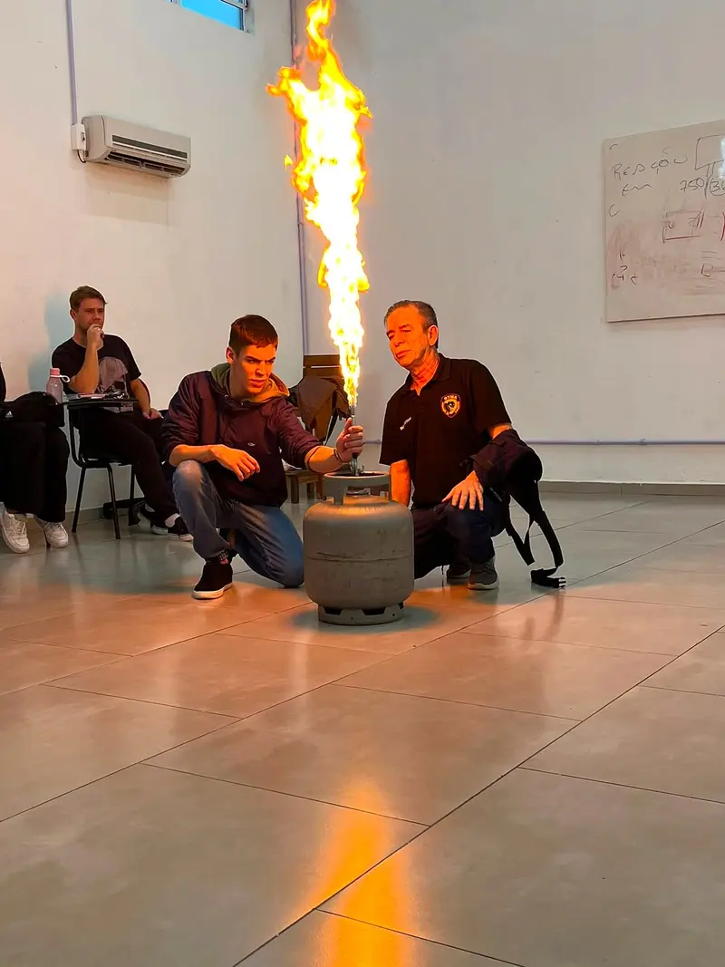 Instrutor da OTMA demonstra o controle de chamas em um botijão de gás na aula de prevenção e combate a incêndio