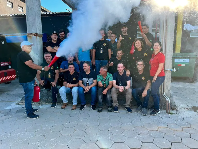 Instrutor dispara um extintor de incêndio diante de uma turma da OTMA durante exercício prático no pátio
